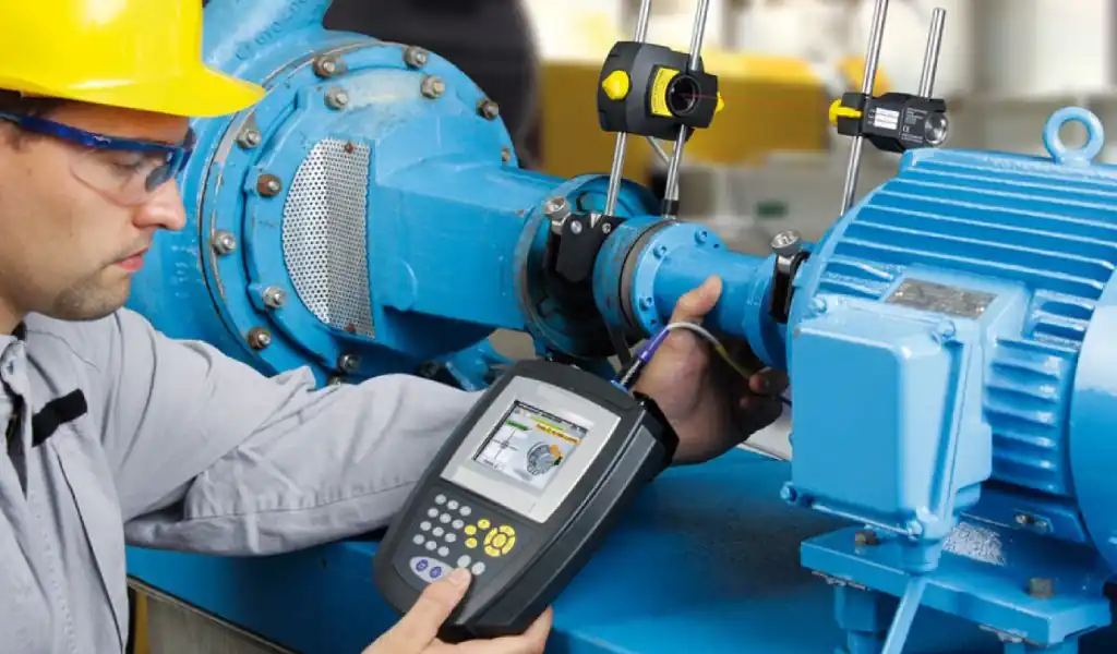 Técnico realizando inspección de un motor industrial utilizando equipos de monitoreo predictivo
